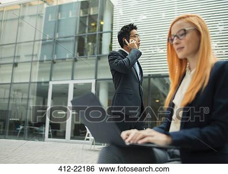 Business people working outside of office building View Large Photo Image Stock Photograph - Business people working outside of office building. Fotosearch