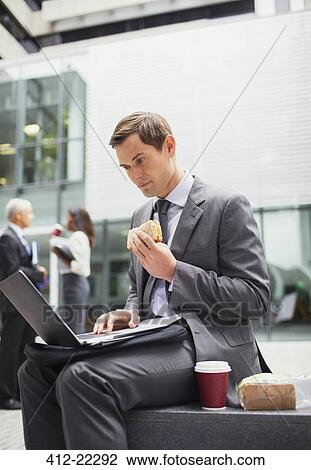 Businessman eat lunch and working outside office building View Large Photo Image Stock Image - Businessman eat lunch and working outside office building. Fotosearch