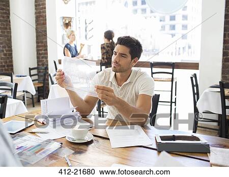 Businessman examining documents in cafe View Large Photo Image Stock Image - Businessman examining documents in cafe . Fotosearch
