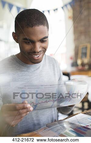 Businessman examining transparency at lunch meeting in cafe View Large Photo Image Stock Image - Businessman examining transparency at lunch meeting in cafe. Fotosearch