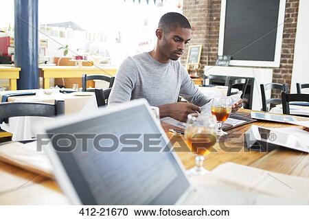 Stock Image - Businessman having lunch meeting in cafe. Fotosearch