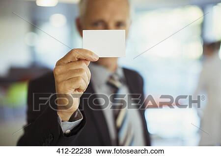 Stock Photo - Businessman holding business card . Fotosearch