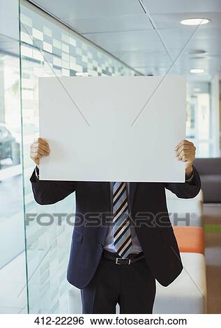 Businessman holding cardboard in office building View Large Photo Image Stock Photograph - Businessman holding cardboard in office building. Fotosearch