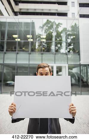 Businessman holding cardboard outside of office building View Large Photo Image Stock Image - Businessman holding cardboard outside of office building. Fotosearch