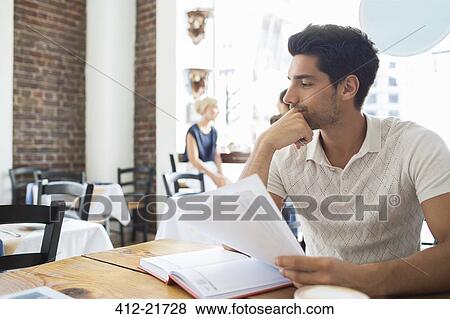 Businessman looking at documents in cafe View Large Photo Image Stock Photo - Businessman looking at documents in cafe. Fotosearch