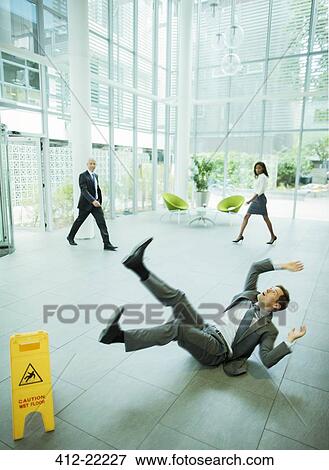Stock Photo - Businessman slipping on floor of office building. Fotosearch