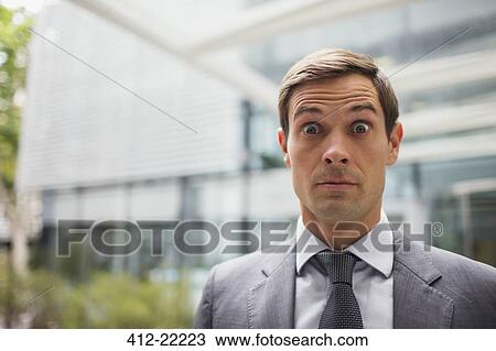 Businessman with eyebrows raised outside office building View Large Photo Image Stock Image - Businessman with eyebrows raised outside office building. Fotosearch