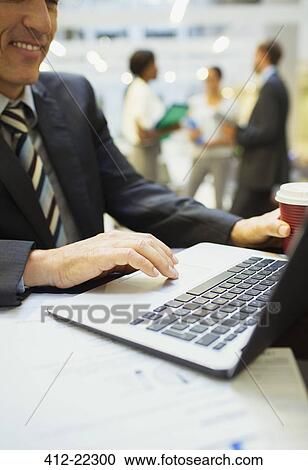 Businessman working on laptop in office building View Large Photo Image Stock Image - Businessman working on laptop in office building. Fotosearch