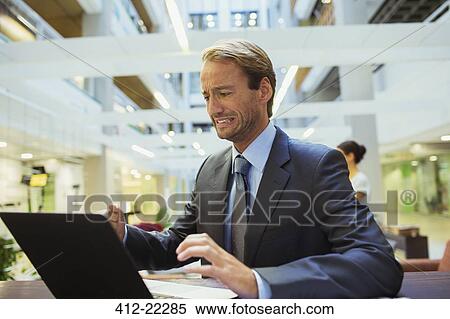 Businessman worried while using laptop View Large Photo Image Stock Photography - Businessman worried while using laptop. Fotosearch