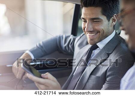 Picture - Businessmen looking at cell phone in car . Fotosearch