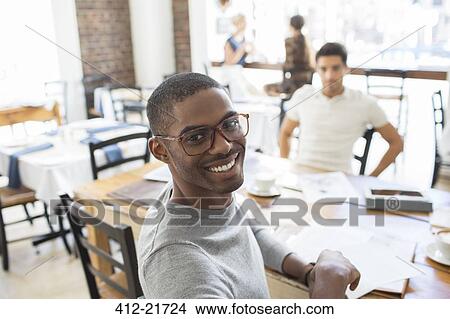 Businessmen looking at documents at meeting View Large Photo Image Picture - Businessmen looking at documents at meeting . Fotosearch