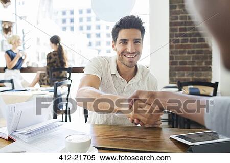 Businessmen shaking hands in cafe View Large Photo Image Stock Photography - Businessmen shaking hands in cafe. Fotosearch
