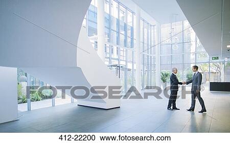 Businessmen shaking hands in office building View Large Photo Image Stock Image - Businessmen shaking hands in office building. Fotosearch
