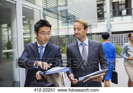 Businessmen talking outside of office building View Large Photo Image Stock Image - Businessmen talking outside of office building. Fotosearch