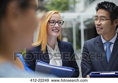 Businesspeople talking outside of office building View Large Photo Image Stock Photo - Businesspeople talking outside of office building. Fotosearch