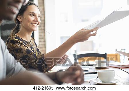 Businesswoman sharing documents at meeting in cafe View Large Photo Image Stock Photography - Businesswoman sharing documents at meeting in cafe. Fotosearch