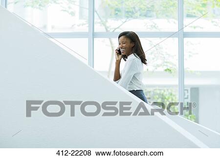Businesswoman talking on cell phone on office stairs View Large Photo Image Stock Photo - Businesswoman talking on cell phone on office stairs. Fotosearch