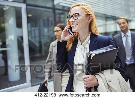 Businesswoman talking on cell phone outside of office building View Large Photo Image Stock Photo - Businesswoman talking on cell phone outside of office building. Fotosearch