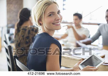 Stock Photograph - Businesswoman using digital tablet at meeting in cafe. Fotosearch