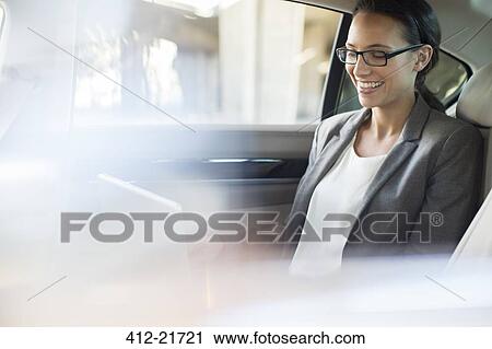 Businesswoman using laptop in car back seat View Large Photo Image Stock Image - Businesswoman using laptop in car back seat. Fotosearch