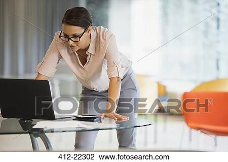 Businesswoman working on laptop in office building View Large Photo Image Stock Image - Businesswoman working on laptop in office building. Fotosearch