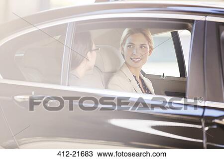 Businesswomen talking in car back seat View Large Photo Image Stock Image - Businesswomen talking in car back seat . Fotosearch