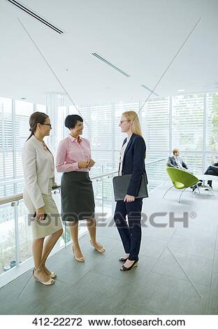 Businesswomen talking in office building View Large Photo Image Stock Image - Businesswomen talking in office building. Fotosearch