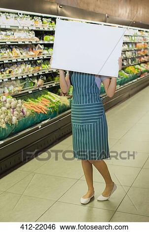 Clerk holding blank card in grocery store View Large Photo Image Stock Photograph - Clerk holding blank card in grocery store. Fotosearch