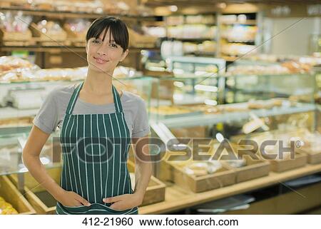 Clerk smiling in deli section of grocery store View Large Photo Image Stock Image - Clerk smiling in deli section of grocery store. Fotosearch