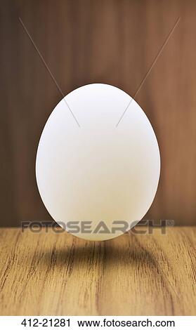 Close up of egg hovering over counter View Large Photo Image Stock Image - Close up of egg hovering over counter . Fotosearch