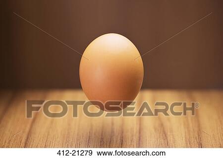 Close up of egg hovering over counter View Large Photo Image Stock Photo - Close up of egg hovering over counter . Fotosearch