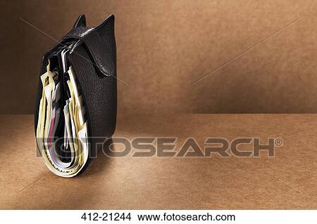 Close up of full wallet standing upright on counter View Large Photo Image Picture - Close up of full wallet standing upright on counter. Fotosearch
