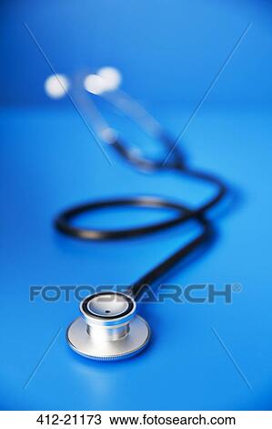 Stock Image - Close up of stethoscope on blue counter. Fotosearch