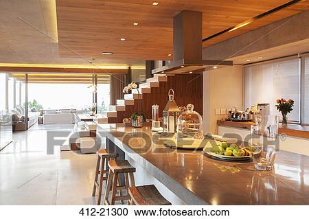 Stock Image - Counter, steps and sofa in open modern house. Fotosearch