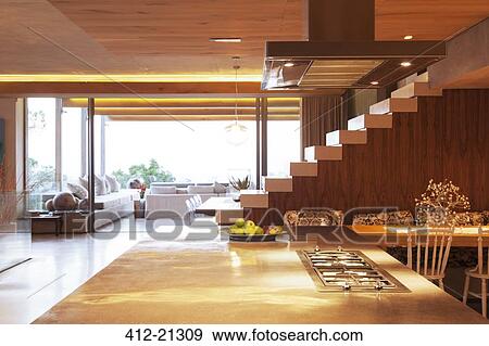 Countertop, staircase, and sofa in open modern kitchen and living area View Large Photo Image Stock Photo - Countertop, staircase, and sofa in open modern kitchen and living area. Fotosearch