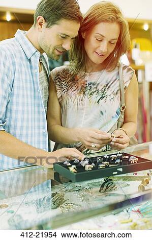 Picture - Couple examining jewelry together in store. Fotosearch