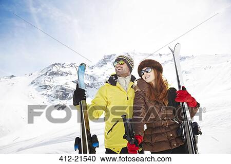 Couple holding skis on mountain top together View Large Photo Image Stock Image - Couple holding skis on mountain top together. Fotosearch