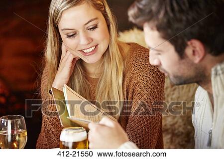 Couple looking at restaurant menu together View Large Photo Image Stock Image - Couple looking at restaurant menu together. Fotosearch