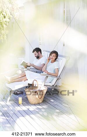 Couple relaxing in lawn chairs on wooden deck View Large Photo Image Stock Image - Couple relaxing in lawn chairs on wooden deck. Fotosearch