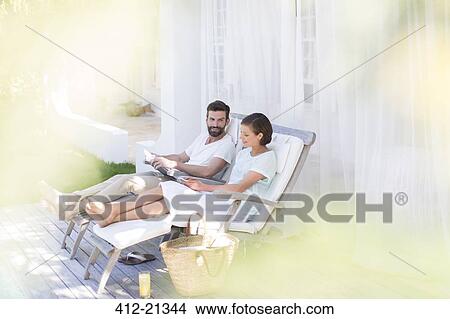 Picture - Couple relaxing together in lawn chairs outdoors. Fotosearch