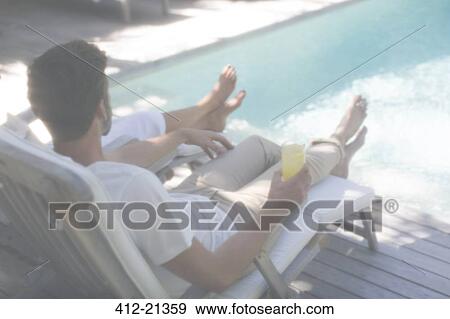 Couple relaxing together in lawn chairs by swimming pool View Large Photo Image Stock Photo - Couple relaxing together in lawn chairs by swimming pool. Fotosearch