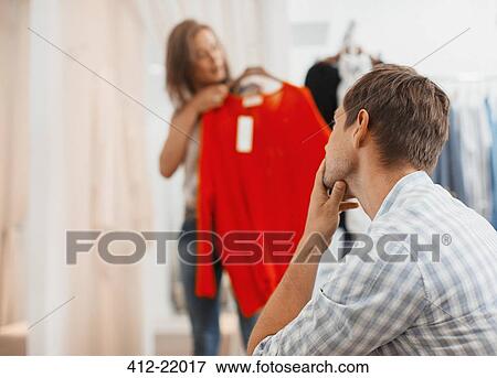 Couple shopping together in clothing store View Large Photo Image Stock Photo - Couple shopping together in clothing store. Fotosearch