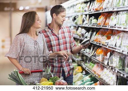Stock Image - Couple shopping together in grocery store. Fotosearch