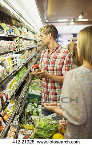 Stock Photo - Couple shopping together in grocery store. Fotosearch