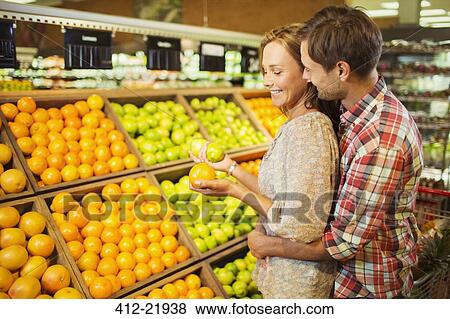 Couple shopping together in grocery store View Large Photo Image Stock Photo - Couple shopping together in grocery store. Fotosearch