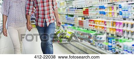 Couple shopping together in grocery store View Large Photo Image Stock Photo - Couple shopping together in grocery store. Fotosearch
