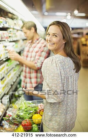 Stock Photography - Couple shopping together in grocery store. Fotosearch