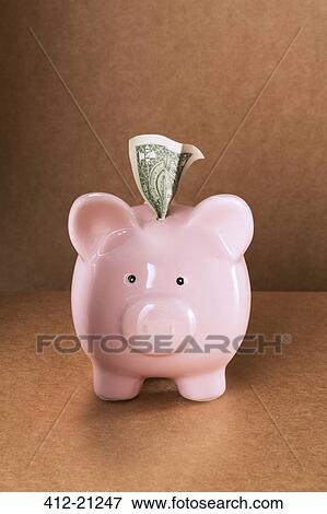 Dollar sticking out of piggy bank on counter View Large Photo Image Stock Photo - Dollar sticking out of piggy bank on counter. Fotosearch