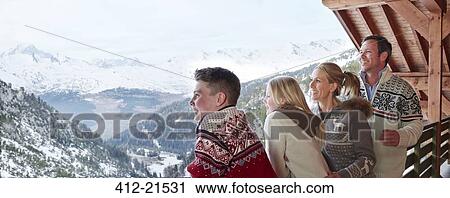 Stock Image - Family looking out from balcony together. Fotosearch