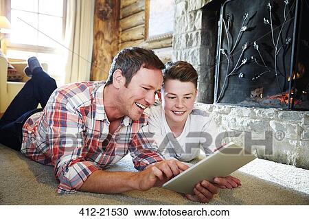 Father and son playing with digital tablet together View Large Photo Image Stock Image - Father and son playing with digital tablet together. Fotosearch